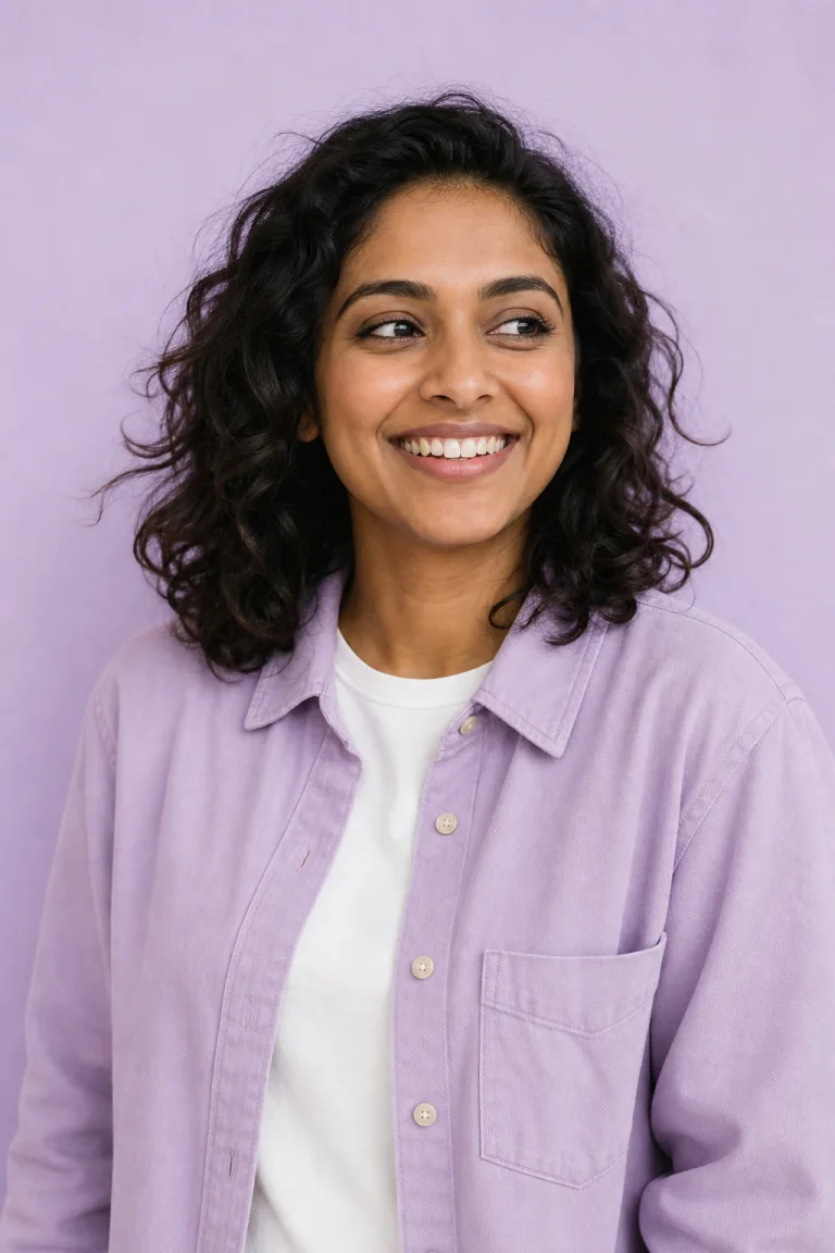 A smiling adult in a lilac overshirt